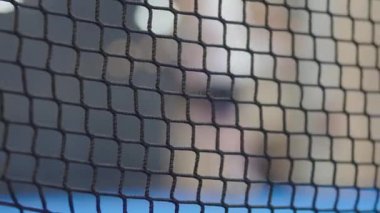 Siyah bir ağa yakın plan ya da tenis kortunda bulanık arka plan ve yumuşak iç aydınlatma, detay ve dokuyu gösteren.