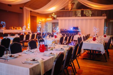 Valmiera, Letonya - 13 Aralık 2024 - VU 20. yıldönümü kutlaması için verilen ziyafet salonu şenlikli yemek masaları, zarif aydınlatma, içkiler ve rahat atmosferle süslendi.