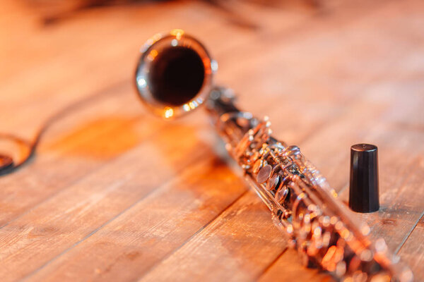 Valmiera, Latvia - December 13, 2024 - Close-up of a clarinet on a wooden stage with warm lighting, showing detailed keys and textures. Copy space on the wooden surface.