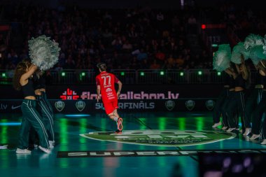 Riga, Letonya - 12 Nisan 2025 - Floorball oyuncusu florball finalleri sırasında arenaya çıkıyor, canlı ışıklar ve kalabalık enerjisi ile karşılanıyor.