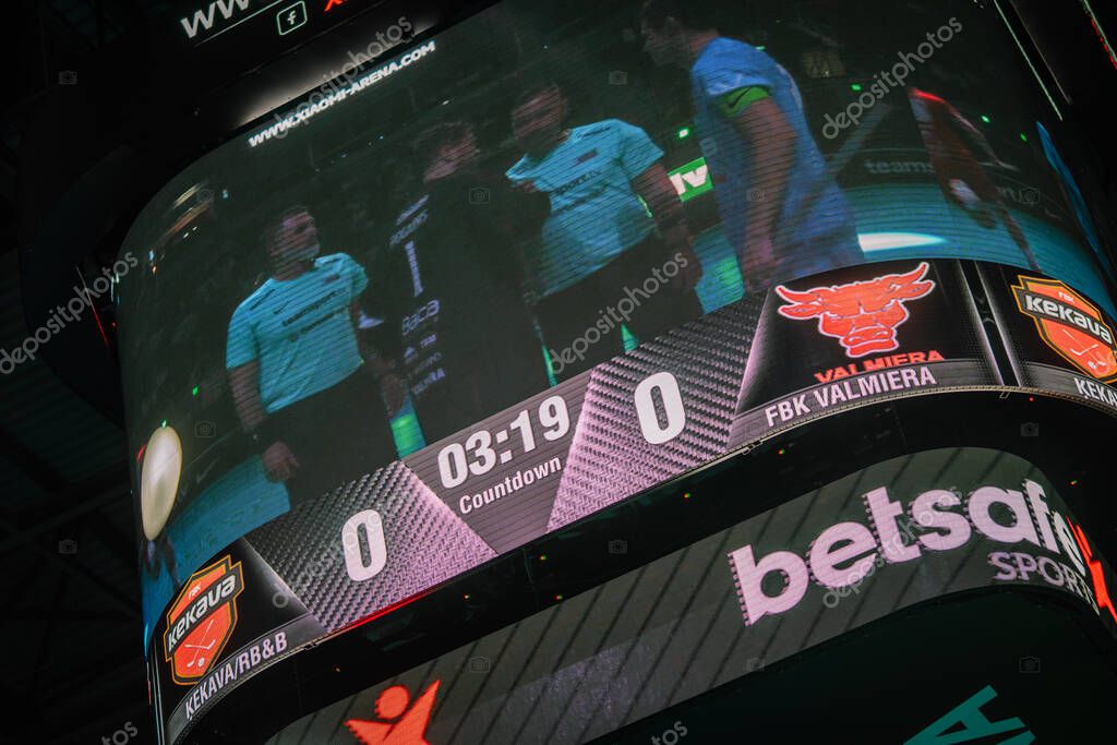 Riga, Latvia - April 12, 2025 - Large scoreboard in arena showing floorball finals between FBK Valmiera and Kekava teams, countdown before game starts, vibrant sports atmosphere.