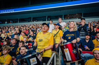 Riga, Letonya - 12 Nisan 2025 - Sarı ve mavi tezahürat ve dolu arenada davul çalan heyecan dolu florbol taraftarları yoğun zemin topu finalleri sırasında.