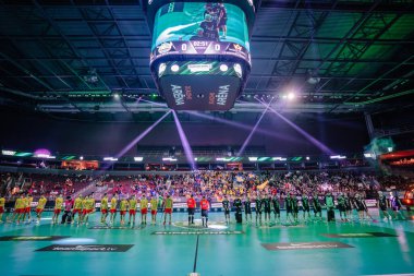 Riga, Letonya - 12 Nisan 2025 - İki florbol takımı maç başlamadan önce sahada hizalandılar modern kapalı alanda seyircilerin ve canlı ışıkların olduğu bir arenada.