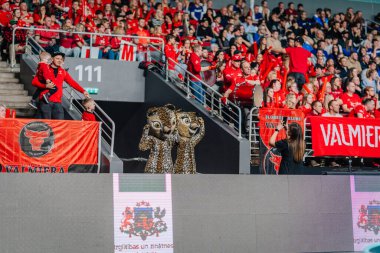 Riga, Letonya - 12 Nisan 2025 - FBK Valmiera taraftarları flama finallerinde davul, pankart ve maskotlarla kırmızı tezahürat yaparak neşeli ve enerjik bir arena atmosferi yarattılar..