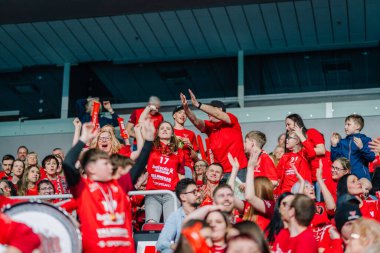 Riga, Letonya - 12 Nisan 2025 - Her yaştan FBK Valmiera taraftarları coşkulu arena seyircilerinin katıldığı finallerde kollarını kaldırarak, pankart ve köpük çubuklarıyla tezahürat yapıyorlar..
