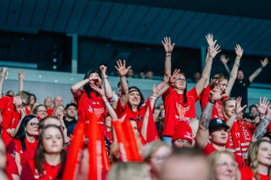 Riga, Letonya - 12 Nisan 2025 - Neşeli FBK Valmiera taraftarları arenada heyecan verici ve birleşik bir kalabalık ortamı yaratarak, kırmızı tezahüratlı ellerini kaldırdı.