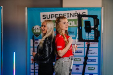 Riga, Letonya - 12 Nisan 2025 FBK Valmiera formalı gülümseyen genç kadın 360 video kabininde poz veriyor..