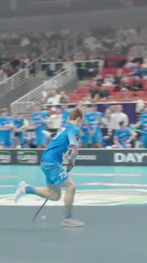 Riga, Letonya - 12 Nisan 2025 - Kekava takımının mavi formalı oyuncularının top sürdüğü, savunduğu, gol attığı ve kapalı bir arenada gol attığı final maçı.