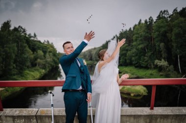 Gelin ve damat bir köprüde durur, neşeyle nehre bozuk para atarlar sembolik ya da eğlenceli bir düğün geleneği olarak..