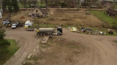 Valmiera, Letonya - 16 Nisan 2025 - Kumlu çöp kamyonu inşaat alanına giriyor, toprak yüzeyde yavaşça ilerliyor.