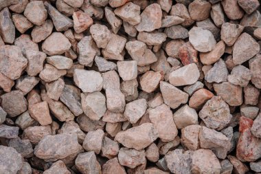 Geniş, açılı, gri ve bronz yapı taşlarının yakın plan görüntüsü. Genellikle ağır zeminde kullanılan dokulu ve doğal bir yüzey oluşturuyor..