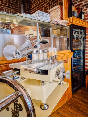 Milan, İtalya - 5 Nisan 2025 - Pizza kutuları ve ahşap mobilyalarla çevrili rahat bir restoran içinde soslu klasik et dilimleyici.