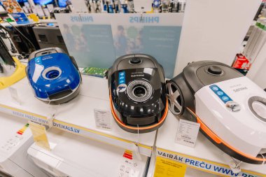 Valmiera, Letonya - 23 Nisan 2025 - Philips teneke kutu elektrikli süpürgelerinin mavi, siyah ve beyaz olarak sergilenmesi, bir elektronik mağazasında fiyat etiketleriyle sergileniyor..