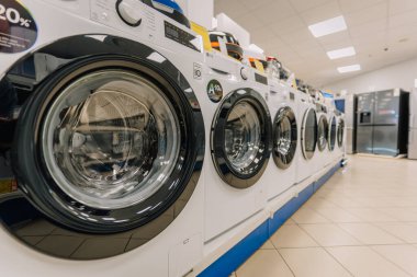 Valmiera, Letonya - 23 Nisan 2025 - Bir elektronik mağazasında sergilenen modern ön yükleme makinelerinin dijital denetim ve enerji verimliliği etiketleri.