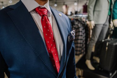 Valmiera, Letonya - 23 Nisan 2025 - Donanma takımı giyen, kırmızı desenli kravat takan ve desenli cep mendili takan bir adama yakın çekim.