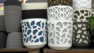 Valmiera, Letonya - Nisan 23, 2025 - Modern kesim desenli, beyaz, gri ve nötr tonlu dekoratif plastik saksı yığını.