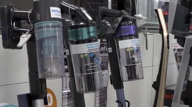 Valmiera, Letonya - 23 Nisan 2025 - Philips ve Samsung kablosuz elektrik süpürgelerinin yakın görüntüsü bir elektronik mağazasında sergilenmekte, modern temizlik aletlerini vurguluyor.
