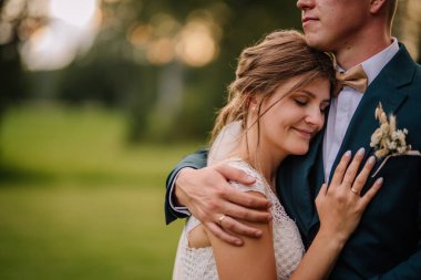 Gelinin duygusal yakınlaşması. Açık havada bir düğün anında damat sandığında huzur içinde dinleniyor. Sevgi, güven ve bağ gösteriyor.