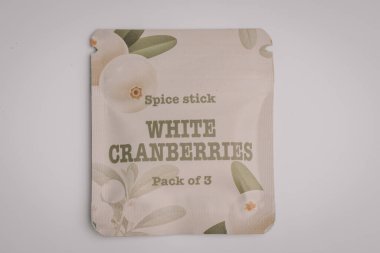 Beyaz CRANBERRIES etiketli krem renkli baharat paketi yumuşak botanik çizimler ve temiz bir arkaplan ile