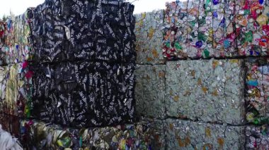 Kudumlar, Letonya - 28 Nisan 2025 - Jack Daniels gibi markalı teneke kutular da dahil olmak üzere ezilmiş alüminyum kutular endüstriyel atık tasnif alanında geri dönüşüm için sıkıca balyalandı.