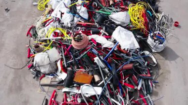 Bir geri dönüşüm ya da atık tasnif tesisinde atılmış renkli, karmaşık kablo, kablo ve plastik boruların yakın çekim görüntüsü.