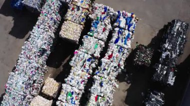 Kudumlar, Letonya - 28 Nisan 2025 - Dönen hava kamerası sıkışık sıkıştırılmış atık balistik, teneke ve kartonsatları bir sanayi geri dönüşüm merkezi avlusunda yakalar.