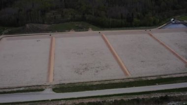 Kudumlar, Letonya - 28 Nisan 2025 - Atık depolamaya hazır, çitlerle çevrili ve ormandaki yollara erişimi olan boş bir depo hücresinin havadan görüntüsü.