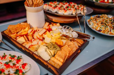 Peynir tabağı, çeşitli peynirler, krakerler, galeta çubukları ve baharatlı yumurtalar bir açık büfe masasında hazır yemek ya da parti için..