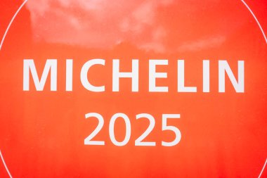 Riga, Letonya - 3 Mayıs 2025 - Kırmızı Michelin 2025 plaketi prestijli restoran tanınmasını ve aşçılık mükemmelliğini simgeleyen koyu beyaz metni gösteriyor.