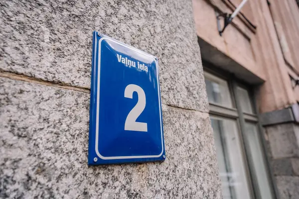 Riga, Letonya - 3 Mayıs 2025 - 2 Valnu iela 'nın Riga, Letonya' da gri granit bir duvara monte edildiğini gösteren mavi emaye sokak tabelası. Sadece editör kullanımı