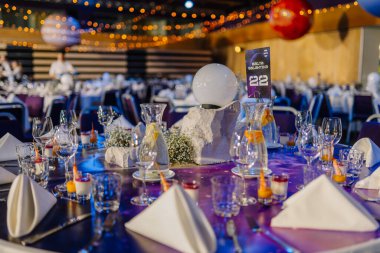 Riga, Letonya - 26 Nisan 2025 - Galaktika masa 22 Galaktika Galaktika Galaktika Galaktika Galaktik Galaktik Galaktik Galaktik Galaktik Galaktik Galaksi Galaksileri, tatlı, turunçgil suyu sürahileri ve sıcak festival salonunun ışıkları altında parlayan süs süsü.