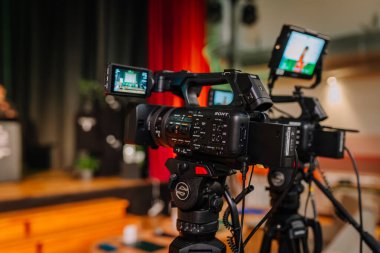 Valmiera, Letonya - 24 Nisan 2025 - Konferans. Profesyonel bir Sony video kamerasının canlı bir olayı ya da sunumunu gerçek zamanlı gösteren monitörlerle yakın plan görüntüsü..