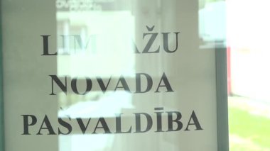 Limbazi, Letonya - 8 Mayıs 2025 - Limbau novad (Limbai Belediyesi) yazılı cam panel, bir hükümet binasında veya kamu binasının girişinde yer almaktadır..