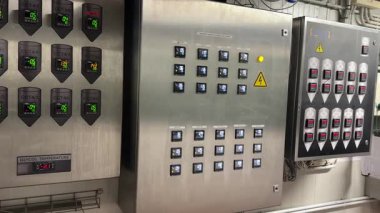 Valmiera, Letonya - 17 Mayıs 2025 - Paslanmaz çelik endüstriyel kontrol panelleri sıcaklık değerlerini gösteren dijital ekranlar ve bira fabrikası fermantasyon izleme için etiketli CCT birimleri.