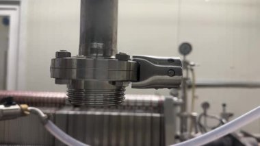Valmiera, Letonya - 17 Mayıs 2025 - Basınçlı sıvı sisteminde veya işleme hattında kullanılan paslanmaz çelik bir boru eşleştirilmiş eklem ve hortum konnektörüne yakın çekim.