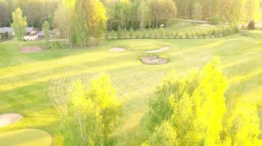 ValmierA, LATVIA - 21 Mayıs 2025 - İHA videosu kum sığınakları, ağaçlar ve yemyeşil bir golf sahası olduğunu gösteriyor..