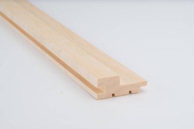 Temiz kenarları ve birbirine kenetlenmiş profili olan, beyaz arka planda görünen hafif ahşap kalıplı parça. Ürün kullanımı için kopyalama alanı içerir.