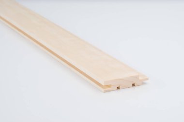 Açık renkli ahşap profil, karmaşık yiv dizaynı, beyaz arka planda fotoğraflanmış. İnşaat veya dolap için hassas bileşen.