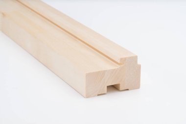 Beyaz arka planda belirgin kesikler ve oyuklara sahip hafif ahşap doğrama profil bloğu. Kapı veya pencere çerçevesi inşası için ideal.