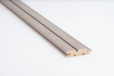 Beyaz arka planda belirgin paralel oyukları olan gri tonlu ahşap çizgiler. Akustik panel ya da dekoratif duvar kurulumu için ideal.