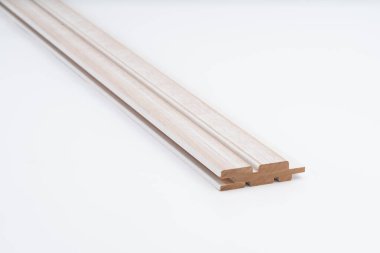 Değirmenli oyukları ve pürüzsüz yüzeyi beyaz arka plana yerleştirilmiş, açık tonlu ahşap kaplama. Modern duvar panelleri veya tavan kaplaması için ideal.