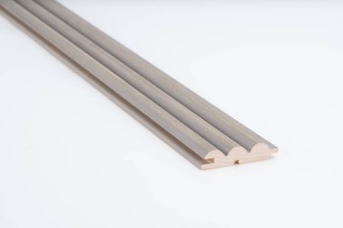 Beyaz arka plana yerleştirilmiş pürüzsüz yüzey ve üçlü kemer oyukları ile gri yuvarlak ahşap kaplama profili. Duvar dekorasyonu ya da akustik kaplama için mükemmel..