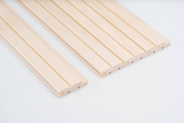 Açık ahşap duvar panelleri flütlü tasarım ve dil ve oluklu bağlantılar, beyaz arka planda düzgünce yerleştirilmiş. Dekoratif iç dekorasyon için ideal.