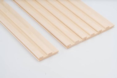 Adımlı profilli, beyaz arka planda hizalanmış Lightwood yivleri. Dekoratif veya akustik iç panel uygulamaları için uygundur.