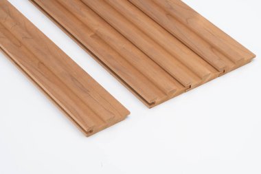 Kahverengi ahşap levhalar, beyaz bir yüzeye düzgün bir şekilde yerleştirilmiş. Duvar panelleri veya akustik kaplama kullanımı için ideal.