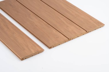 İç kaplama ya da akustik kullanım için beyaz bir zemin üzerine düzgün sıralanmış, ince tahıllar ve derin oyuklar ile kahverengi tahta levhalar.