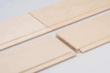 Pürüzsüz yüzeyleri ve dil ve oyuk eklemleri olan birbirine kenetlenmiş ahşap panellere yakın çekim, döşeme ya da paneller için ideal. Minimalist beyaz arkaplan.