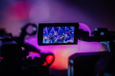 Valmiera, Letonya - 22 Mayıs 2025 - Kamera ekranından bir konser performansı izlendi, gitarlar, Yamaha enstrümanları ve profesyonel bir kurulumda canlı ışıklar ile bir sahne kaydedildi.