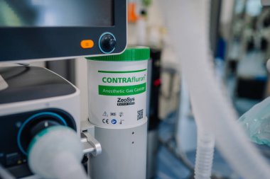 Valmiera, Letonya - 31 Mayıs 2025 - ZeoSys tarafından bir CONTRAfluran anestezi tüpüne yakın çekim, tıbbi anestezi makinesine bağlı tüpler ve monitörlerle.