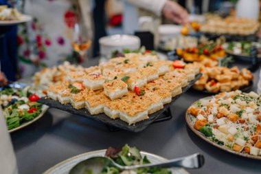 Valmiera, Letonya - 31 Mayıs 2025 - Açık büfe masası, üstü tatlı barları ile kaplı, salata ve parmak yiyecekleri ile çevrili..
